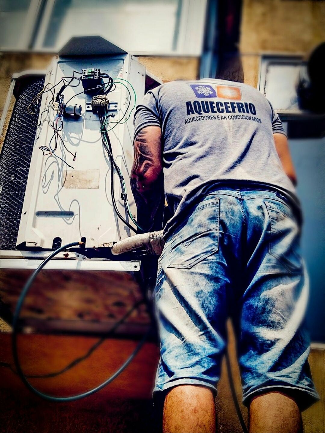 Técnico da Aquece Frio trabalhando na condensadora de um ar-condicionado