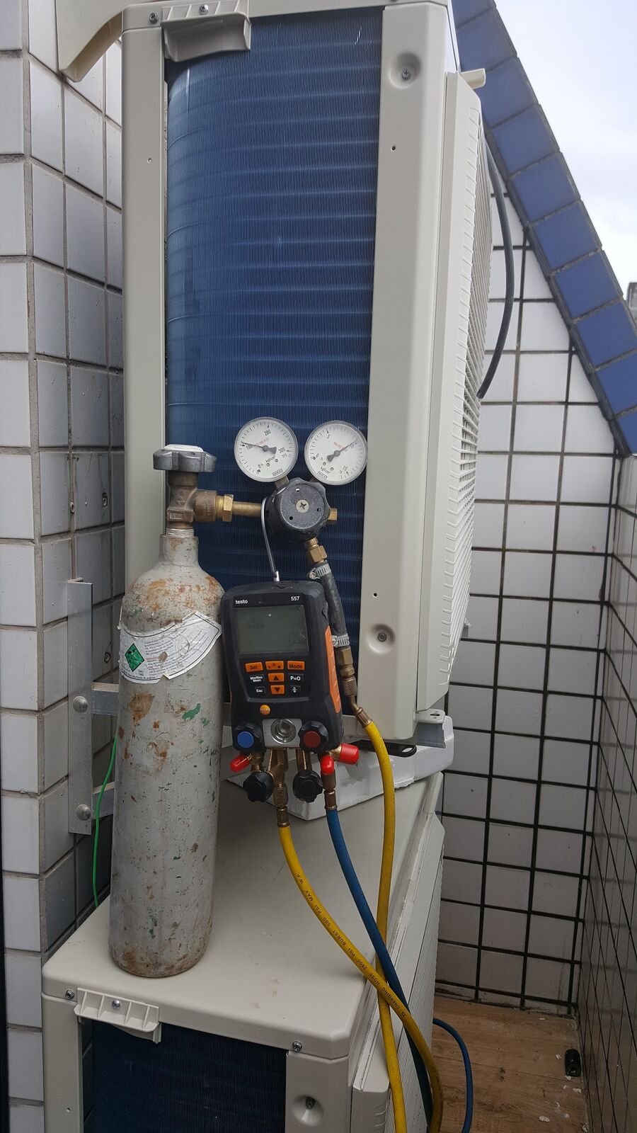 Manômetro e bomba ligados à condensadora durante o teste da instalação